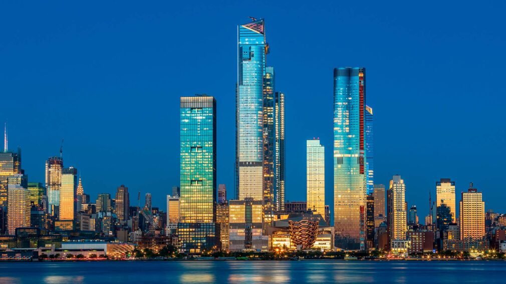 View to Manhattan skyline from Weehawken Waterfront in Hudson River at sunset.